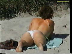 Topless girl putting on sun lotion